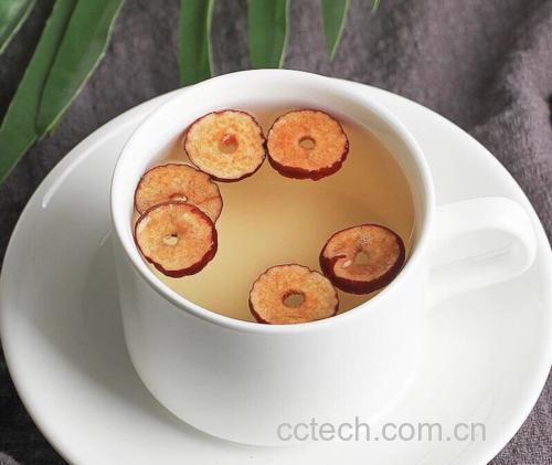 盛在白瓷碗中的蚕豆红枣汤,散发出淡淡香气,背景模糊营造温馨氛围 蚕豆红枣汤成品图,配有勺子和蒸汽效果