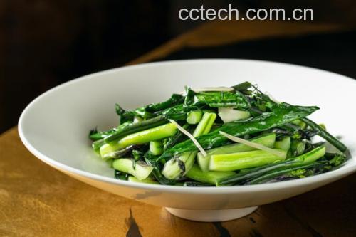 洁白瓷碗中盛放着金黄的小葱饼块与翠绿葱花、棕褐色虾皮混合的拌菜,表面点缀少许红椒丝与芝麻,旁边配一小碟酱油蘸料,整体色彩鲜明,食欲感强烈 成品装盘展示
