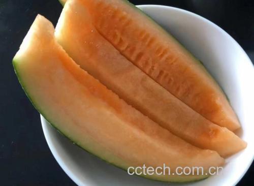 图中展示一碗切好的西瓜旁边放着一小勺蜂蜜,背景为清新厨房环境 吃西瓜喝蜂蜜的健康搭配
