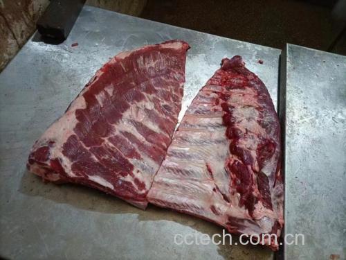 桌上摆放着新鲜的蒜薹、猪肉和面粉,背景为厨房操作台 蒜薹与猪肉原料展示
