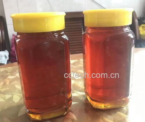 一杯透明玻璃杯中盛有淡黄色液体,加入了少量蜂蜜和陈醋 一杯混合了蜂蜜和陈醋的水