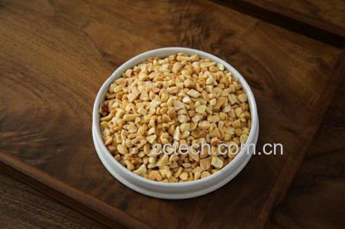 桌上摆放着一碗温水和一小碟未加盐的原味花生,背景为阳光洒进的厨房 花生的健康食用方式