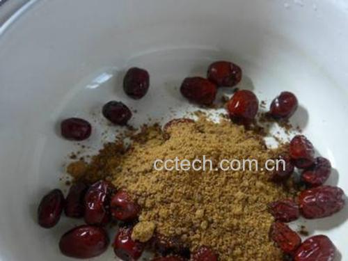 一名厨师正在用打蛋器将深红色的红枣泥缓缓倒入白色温牛奶中,两者在透明玻璃容器内逐渐融合,画面清晰展现液体流动状态,强调搅拌动作与均匀混合的重要性 红枣泥与温牛奶混合搅拌过程