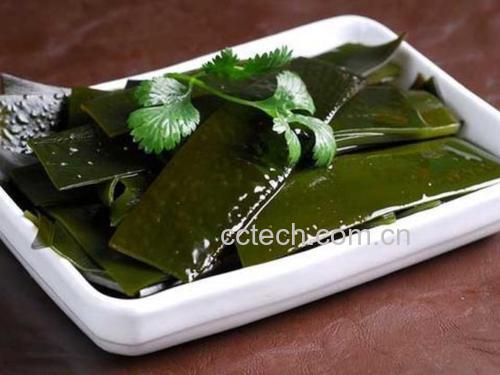 一道精致的家常凉拌香菜菜肴,盘中香菜翠绿鲜亮,混合红椒丝和蒜末,淋有少许酱汁,摆盘整洁,背景为木质餐桌,体现健康饮食场景 香菜凉拌菜成品图