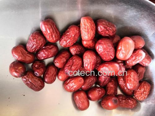 一碗热腾腾的甘蔗红枣水,旁边摆放着新鲜甘蔗段和红枣 甘蔗红枣煮水