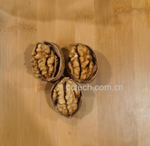 薄皮核桃与其他坚果、水果搭配的创意摆盘,背景为木质餐桌,光线柔和 薄皮核桃美食创意摆盘