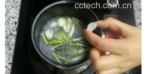 家庭厨房场景:玻璃壶中盛放淡琥珀色葱白水,旁边摆放刚切好的5cm葱白段(带浅褐色根盘)、小瓷杯、计时器显示' title=