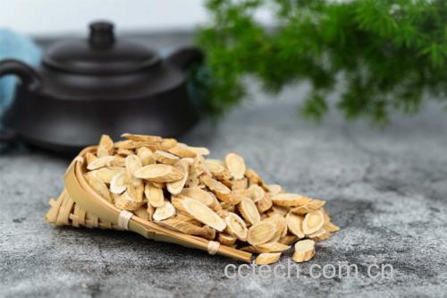 玻璃茶壶中正在冲泡黄芪片与怀牛膝段,热水翻滚,药材舒展,茶汤呈淡黄褐色。旁边摆放量勺与药材罐,展示规范用量,体现科学养生理念 黄芪怀牛膝茶饮冲泡过程