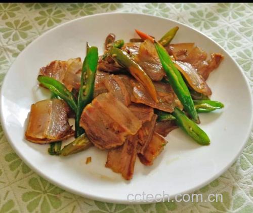 图片说明:辣椒炒肉烹饪过程中翻炒辣椒与肉的场景,展现菜品制作的真实操作画面 辣椒炒肉烹饪过程图