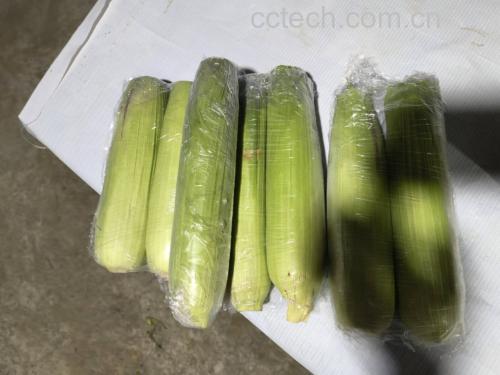 一位女性正在享用一碗由玉米、番茄、黄瓜和橄榄油制成的健康沙拉,桌上铺着亚麻布,环境温馨自然 女性享用玉米沙拉