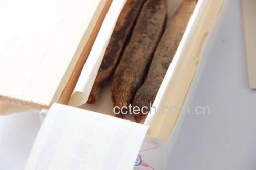 一瓶正官庄红参饮(盒装小瓶浓缩液),背景为红色包装盒和金色品牌标识,液体呈深褐色透明状,旁边摆放一整根红参以展示原料来源 红参饮正官庄产品图