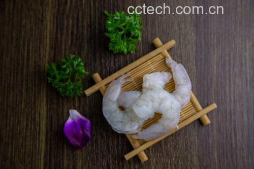 新鲜螺丝椒与去壳虾仁整齐摆放在案板上,背景为厨房环境 螺丝椒与虾仁原材料展示