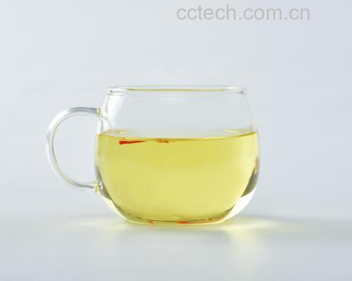玻璃杯中盛放着淡黄色的红参天冬茶,旁边摆放着红参片与天冬碎 红参天冬茶饮成品图