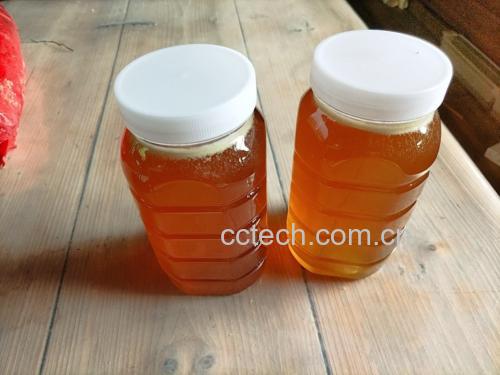 一张木质餐桌上摆放着几个新鲜的突围桃,旁边配有小刀、玻璃杯和蜂蜜,营造出自然健康的饮食氛围 新鲜突围桃果盘展示