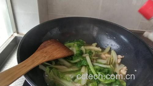 一口铁锅正在旺火翻炒青萝卜片与肉片,锅中食材呈金黄色,肉片柔嫩,萝卜半透明,厨师手持锅铲进行颠勺动作,展现家常炒菜场景 图片描述