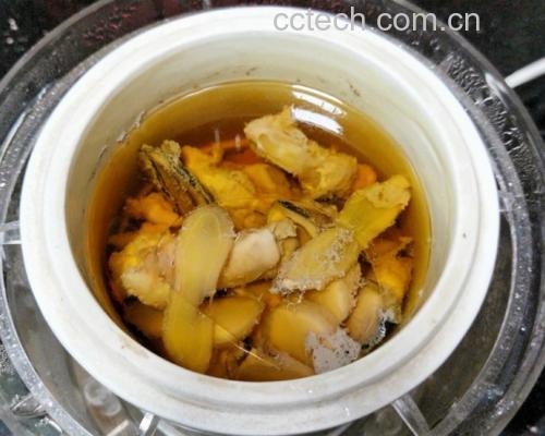 不锈钢小汤锅正在炉灶上小火慢煮,锅中可见金黄色汤液翻滚,漂浮着枇杷果块与陈皮条,旁边放置川贝粉小碟与玻璃量杯,体现专业烹饪场景 枇杷川贝陈皮水熬煮过程