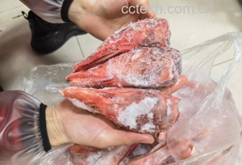 鸭肉正在焯水中,水面泛起浮沫,旁边放着切好的老姜片和料酒 鸭肉焯水过程图
