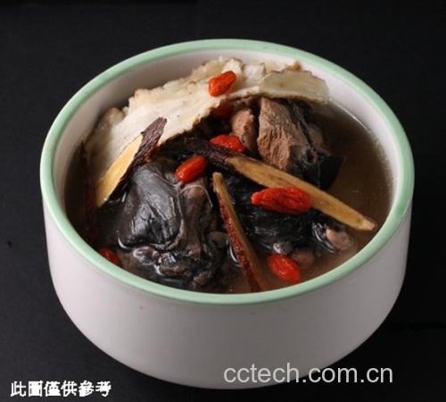 一碗热气腾腾的陶盅内盛有乌鸡汤,汤色清澈微褐,可见当归片贴附盅壁,熟地黄块沉于底部,乌鸡肉块饱满,点缀枸杞与红枣,背景为中式餐桌与竹筷,体现家常养生饮食场景 当归熟地黄乌鸡汤的成品菜肴特写