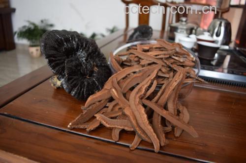 一杯温热的黑芝麻桑叶水,置于木质托盘上,背景为自然光线下的厨房环境 黑芝麻桑叶水成品图