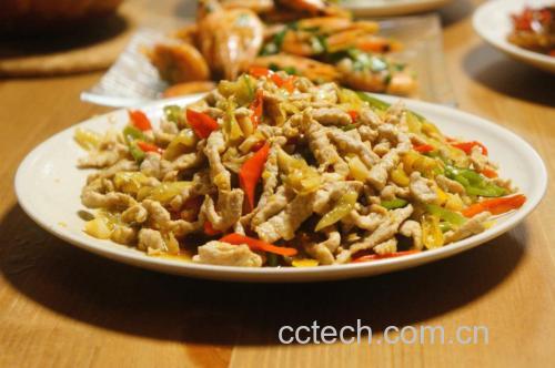餐盘中盛有一道刚出锅的红色尖椒炒肉丝,色彩鲜艳,尖椒红亮,肉丝褐润,点缀蒜片,旁边搭配一碗白米饭,展现诱人的家常美食画面 图片描述