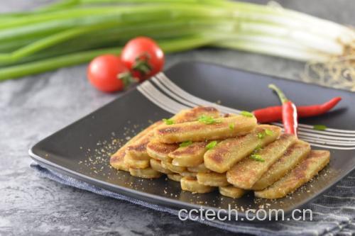 金黄酥脆的扁包菜煎饼,摆放在餐盘中,旁边有蘸料碗和新鲜蔬菜点缀 扁包菜煎饼特写图