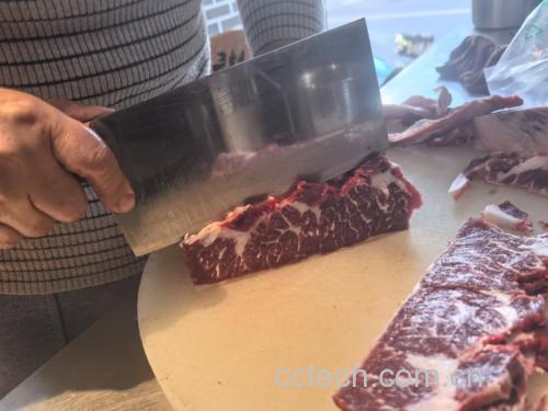 一位中年男子在厨房切菜,背景是各种低脂食材 甘油三酯高人群在厨房准备低脂饮食