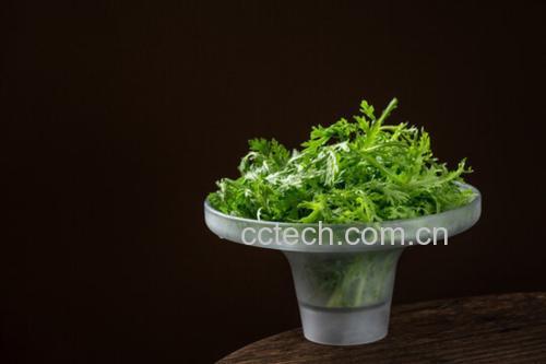 一只白色陶瓷碗中盛满翠绿色的香芹蘸酱,表面淋有一圈金黄色橄榄油,旁边摆放着胡萝卜条、黄瓜条、紫甘蓝片和全麦饼干,背景为木质餐桌与自然光线,整体风格清新健康 香芹蘸酱成品展示