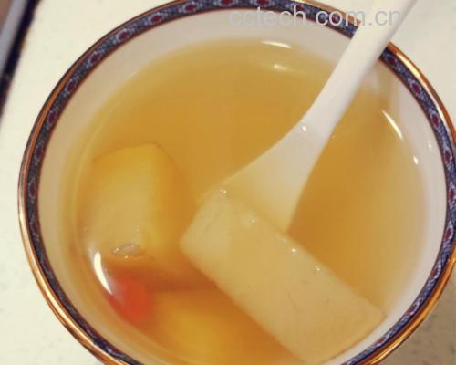 高清俯拍:青花瓷大汤碗中盛满清亮琥珀色羊肉汤,汤面浮着细密金黄油花,不见浑浊;3块炖至软糯微透明的羊腩肉沉于碗底,边缘微卷;汤面撒有翠绿葱花与几粒完整白胡椒粒;碗侧搁置木质胡椒研磨器,内可见少量剩余白胡椒粒;背景为素色麻布台布,营造温润食养氛围 羊肉汤成品特写图
