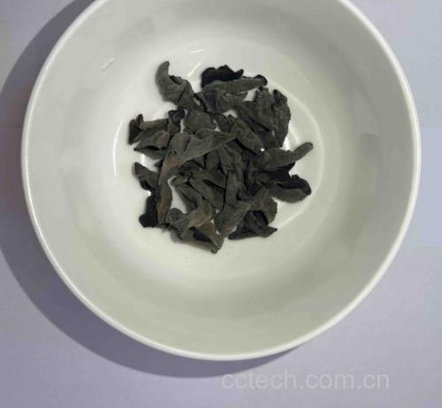 一碗清水中的干秋木耳正在泡发,周围散落着未使用的木耳干片 秋木耳泡发过程