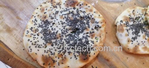 一碗香浓芝麻酱成品,色泽乌黑,质地顺滑,旁边配有筷子和拌面食材 香浓芝麻酱成品图
