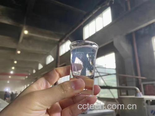 玻璃瓶中浸泡着完整的独头蒜,白酒清澈透明,背景为厨房环境 独头蒜泡酒成品图