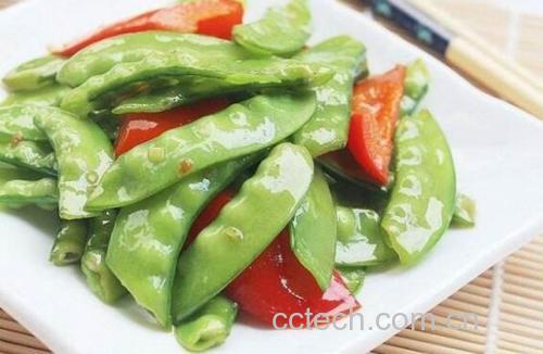 厨师正在用铲子在炒锅中快速翻炒已加入荷兰豆的土豆片,锅中食材呈金黄色与翠绿色交织状态,灶火旺盛,蒸汽升腾,体现‘大火快炒’的烹饪场景 荷兰豆炒土豆片翻炒过程