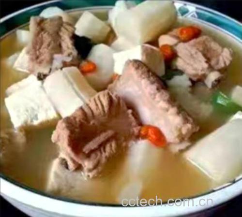 一锅热气腾腾的白扁豆山药排骨汤特写,汤色清亮微白,可见完整的开花白扁豆、排骨块和山药段,表面漂浮少量油星和葱花点缀,旁边摆放瓷勺,背景为原木餐桌,体现家庭温馨氛围 白扁豆山药排骨汤成品图