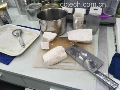 一位中年女性在明亮现代的厨房内操作台前,戴着围裙,手持压泥器将刚出锅的热香芋压成细腻芋泥,旁边放有玻璃碗、勺子和少许椰奶,展现家庭健康烹饪场景 家庭厨房中一位女性正在将蒸好的香芋压成泥,准备制作健康点心