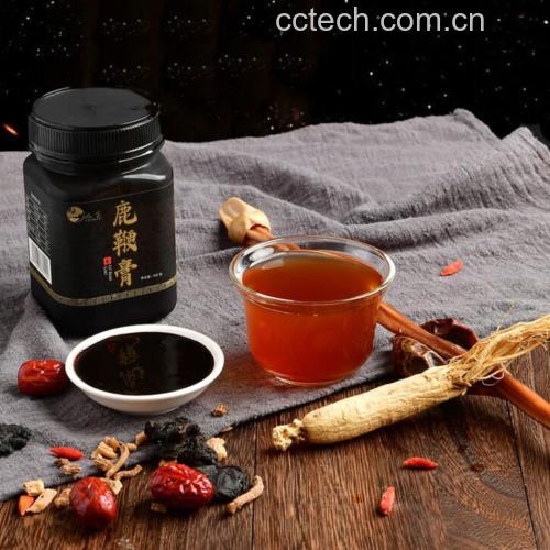 一口砂锅正在慢火炖煮,锅内可见鹿鞭段与枸杞、红枣、鸡肉共煮,汤色乳白,热气腾腾,旁边摆放鹿鞭干品与中药材,展现家庭滋补烹饪场景 鹿鞭炖汤场景图