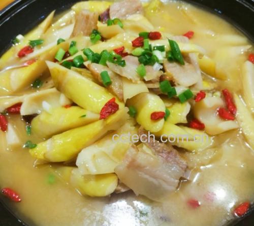 一碗盛满的雷竹笋炖鸡汤特写,汤色清亮微黄,可见炖煮完整的笋块与鸡块交错分布,表面漂浮着几片姜和红色枸杞,背景为暖色调的餐桌,营造温馨家庭用餐氛围 雷竹笋炖鸡汤特写