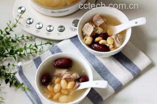一锅热气腾腾的白鸽炖黑豆正在砂锅中缓慢冒泡,汤色呈淡乳白色,黑豆饱满,鸽肉清晰可见,旁边摆放着瓷勺和空碗,营造温馨家庭用餐氛围 白鸽炖黑豆成品汤品展示
