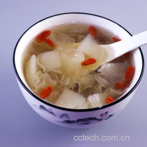 盛在碗中的雪梨银耳莲子羹,色泽金黄,汤体浓稠,点缀枸杞 成品雪梨银耳莲子羹