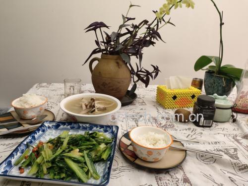 一张木质餐桌上摆放着一盘刚出锅的清炒西兰花,旁边配有米饭和汤碗,光线柔和,营造出温馨的家庭用餐氛围 家庭餐桌上的清炒西兰花拼盘