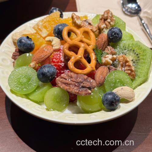一张餐桌上的健康水果拼盘,包含两个剥好的山竹果肉、几颗蓝莓、一片橙子、三颗圣女果和一小撮杏仁,旁边放有一杯无糖酸奶和一把木制小勺,背景为浅色布艺桌布,阳光透过窗户洒入,营造出清新自然的健康饮食氛围 山竹与健康饮食搭配场景