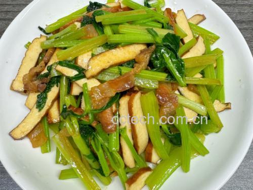 中式炒锅内正在进行翻炒的山芹炒腐竹,食材分布均匀,表面略带酱色光泽,体现恰到好处的火候控制 炒锅中正在翻炒的山芹与腐竹,食材色泽鲜亮,蒸汽升腾,厨师手持锅铲进行颠勺动作