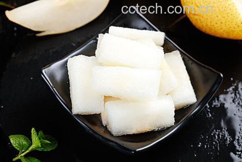 一颗新鲜采摘的香梨被横向切开,露出洁白细腻的果肉,表面有透明汁液渗出,背景为浅色木质桌面,光线柔和,突出水果的水润质感 香梨切开特写,展示其白色果肉与晶莹汁液
