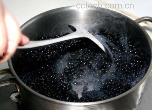 一口陶瓷砂锅置于炉灶上,锅内正在熬煮黑豆,水面泛起轻微泡沫,几颗黑豆漂浮其中,蒸汽袅袅上升,旁边摆放着干净的玻璃杯和漏勺,展示家庭制作黑豆水的真实场景 黑豆熬水过程