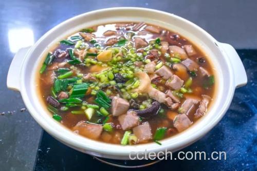 一锅热气腾腾的五花肉荔浦芋头煲刚从灶台端出,深红油亮的酱汁包裹着大块五花肉和雪白的荔浦芋头,表面撒有翠绿葱花,使用黑色砂锅盛装,背景虚化体现家庭餐桌氛围 成品特写图