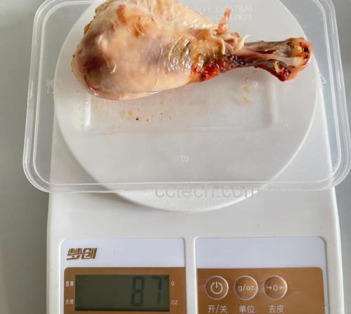 一只新鲜去皮去骨鸡腿肉放置在电子厨房秤上,显示屏清晰显示重量为163克,背景为浅色木质料理台,旁边摆放一把不锈钢厨刀和一节切好的大葱段,突出食材真实感与测量准确性 鸡腿称重示意图