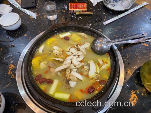 一个白色瓷盘里整齐摆放着数十片干红枣片,置于不锈钢蒸架上,下方锅中水已沸腾冒出白色蒸汽,厨房背景整洁明亮,显示传统中式蒸锅使用场景 红枣蒸制过程