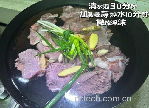 锅中牛肉块正在冷水加热焯水,水面有大量灰白色浮沫冒出,旁边摆放着姜片、葱段和料酒瓶,用于去腥处理 牛肉焯水过程