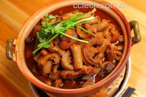 砂锅中牛肉正在小火慢炖,汤面微微冒泡,锅盖半开,可见牛肉块已呈深褐色,汤汁浓稠,周围摆放着八角、香叶等香料 炖牛肉慢火 simmering