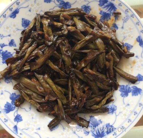 干煸四季豆最终成品图:突出虎皮纹理、油润度适中、配料分布均匀、色泽鲜明有食欲 干煸四季豆成品特写:深翠带褐斑的四季豆整齐铺于白瓷盘中,表面油润不泛光,可见清晰虎皮纹路,点缀金黄蒜末、焦红辣椒段与青翠葱花,背景虚化木质餐桌
