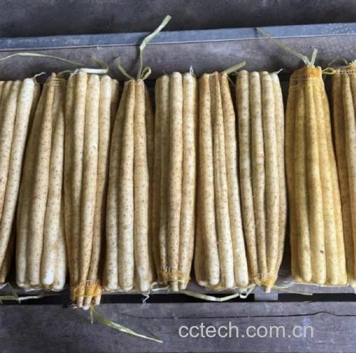 一盘刚出炉的金黄色山药棒摆放在竹制托盘上,表面微微泛油光,散发热气,背景为打开的空气炸锅,旁边配有糖粉筛子和桂花瓶 山药棒在空气炸锅中烘烤完成